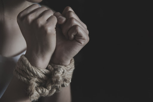 A person whose hands are bound with rope